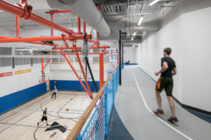 Running on track that overlooks with gym, men shooting hoops